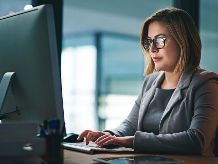 Junge Frau arbeitet abends am PC