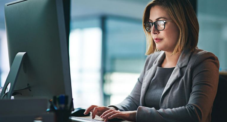Junge Frau arbeitet abends am PC
