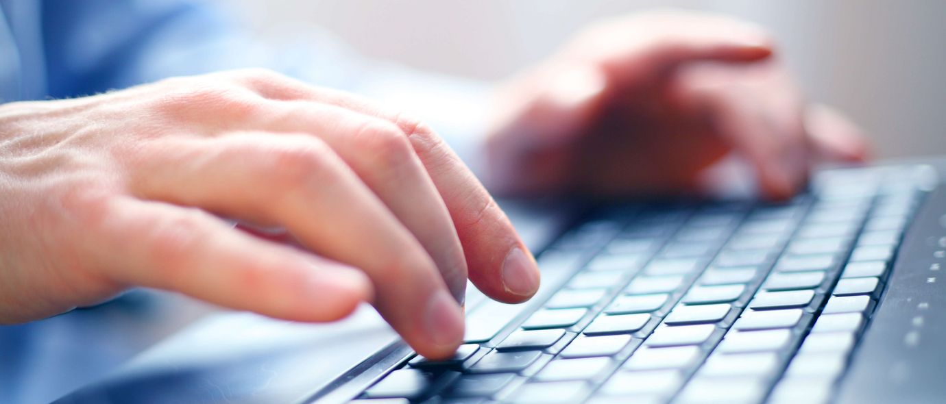 Hände benutzen eine Computertastatur