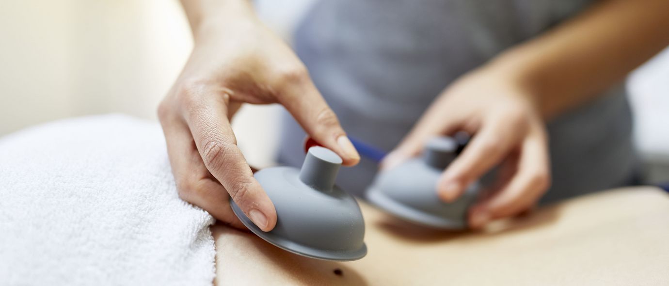 Physiotherapeutin bereitet Rücken für Elektrotherapie vor
