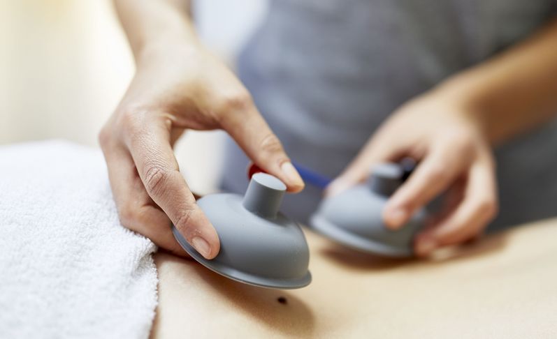 Physiotherapeutin bereitet Rücken für Elektrotherapie vor