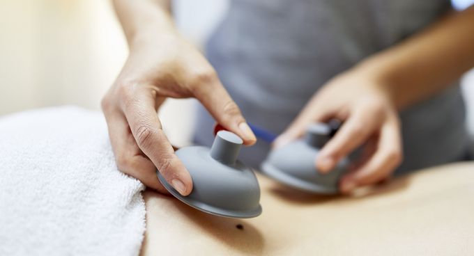 Physiotherapeutin bereitet Rücken für Elektrotherapie vor