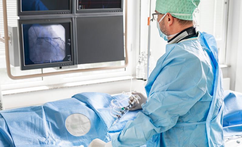 Arzt mit Maske und Haube führt minimalinvasive Operation durch