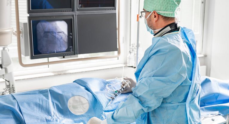 Arzt mit Maske und Haube führt minimalinvasive Operation durch