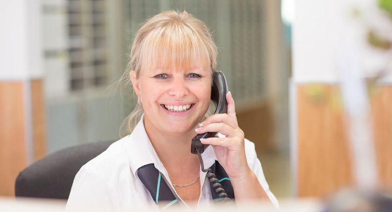 freundliche Rezeptionisten telefoniert an der Rezeption